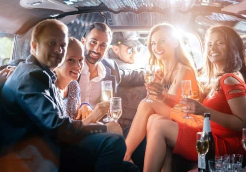 Group of party people in a limo drinking looking at the camera